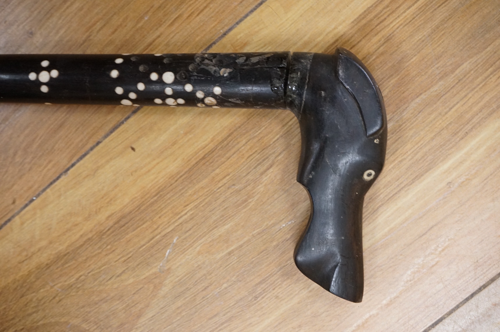 An ebony walking stick with bone inlay, the handle in the form of a dog's head, 88cm in length